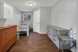 Bedroom with dark wood-type flooring and baseboards
