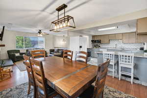Dining area featuring light wood-type flooring, a chandelier, and a ceiling fan