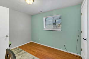 Unfurnished bedroom featuring wood finished floors and baseboards