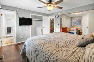 Bedroom featuring dark wood-style floors, connected bathroom, ceiling fan, and a closet
