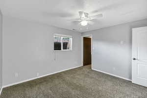 Carpeted spare room featuring a ceiling fan and a textured ceiling