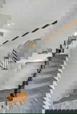 Stairs featuring wood finished floors and recessed lighting