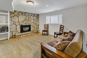 Carpeted living room featuring a fireplace and a textured ceiling