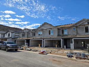 Unfinished property featuring a garage and stucco siding