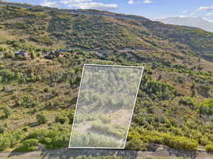 Aerial view of property's location with property boundaries highlighted and a mountain backdrop