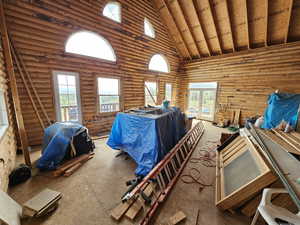 Bedroom with high vaulted ceiling and multiple windows