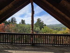 Wooden deck featuring a view of trees and a mountain view