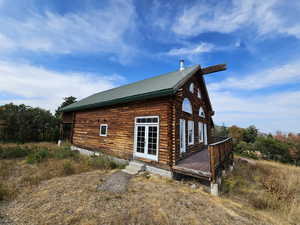 View of side of property with a metal roof, log siding, and a deck