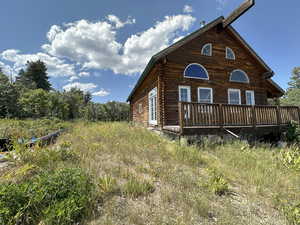 View of side of property featuring log siding and a deck