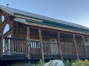 View of side of property with a metal roof, log siding, and a deck