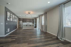 Unfurnished living room with dark wood-type flooring and recessed lighting