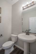Bathroom featuring toilet and dark wood-style floors