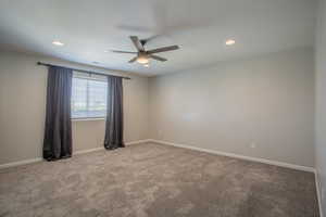 Empty room featuring light colored carpet, ceiling fan, and recessed lighting