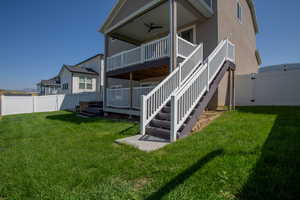 Rear view of house featuring stairs, a fenced backyard, a wooden deck, and a ceiling fan