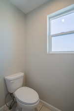 Bathroom featuring toilet and tile patterned flooring