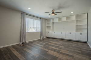 Empty room featuring ceiling fan, dark wood-style floors, a textured ceiling, and recessed lighting