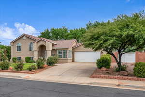 Mediterranean / spanish home with stucco siding, a tile roof, concrete driveway, and a garage