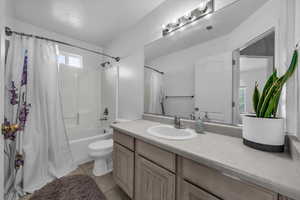 Full bathroom with shower / bath combo, vanity, and light tile patterned floors