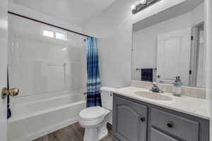 Bathroom featuring shower / tub combo, vanity, and wood finished floors