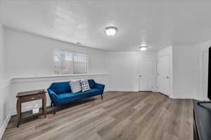 Sitting room featuring light wood-style floors and a textured ceiling
