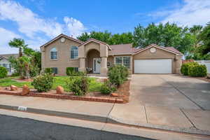 Mediterranean / spanish house featuring stucco siding, driveway, an attached garage, a tiled roof, and a front yard
