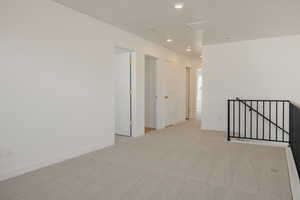 Spare room featuring light carpet and recessed lighting