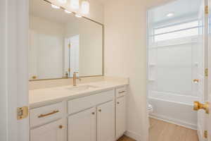 Bathroom with vanity, light wood-type flooring, and shower / bathtub combination