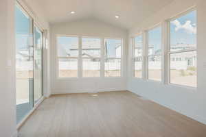 Unfurnished sunroom featuring wood finished floors, lofted ceiling, and recessed lighting