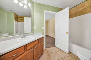 Bathroom with shower / tub combination, vanity, and light tile patterned floors