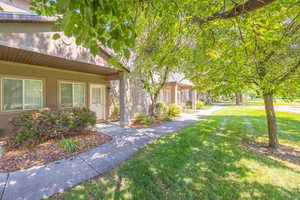 Property entrance featuring a yard and stucco siding