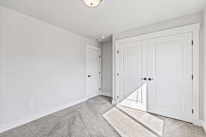 Unfurnished bedroom with carpet flooring and a closet
