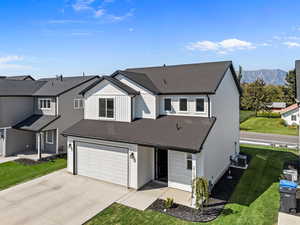 View of front facade with board and batten siding, driveway, a garage, and roof with shingles