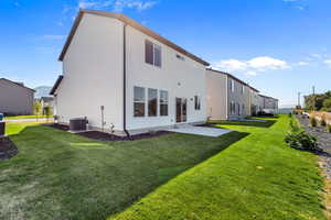 Back of property with a patio and a lawn