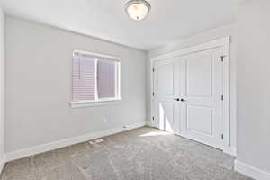 Unfurnished bedroom with carpet and a closet