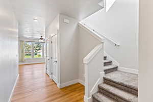 Staircase featuring wood finished floors and ceiling fan