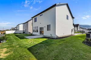 Back of property featuring a patio area, a mountain view, and a residential view
