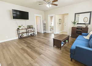 Living room with light wood finished floors and a ceiling fan