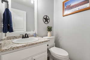 Half bathroom with vanity and toilet