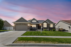 View of front of home featuring driveway, covered porch, and a garage
