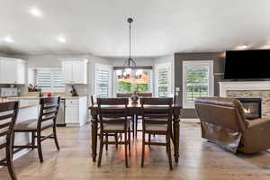 Dining space with recessed lighting, a fireplace, a chandelier, and light wood finished floors
