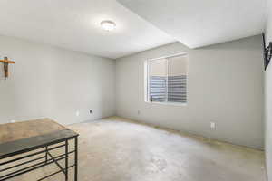 Unfurnished room featuring concrete flooring and a textured ceiling