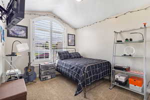 Bedroom featuring vaulted ceiling and light carpet