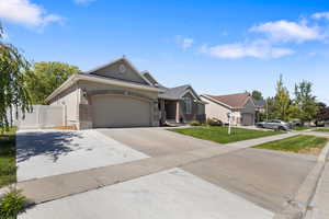 Ranch-style house featuring concrete driveway, brick siding, and a garage
