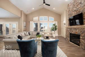 Living room with a stone fireplace, healthy amount of natural light, high vaulted ceiling, wood finished floors, and a ceiling fan