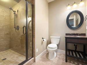 Bathroom with a shower stall, tile patterned floors, and vanity
