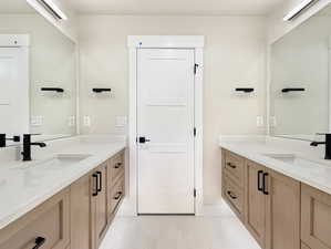 Bathroom with two vanities and light tile patterned floors
