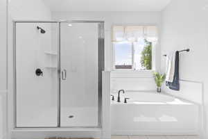 Bathroom with tile patterned floors, a shower stall, and a garden tub