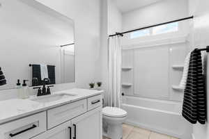 Full bathroom featuring shower / bath combo with shower curtain, vanity, and light tile patterned flooring