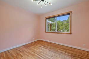 Empty room featuring a chandelier and light wood finished floors