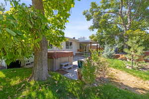 View of yard with a hot tub and a patio